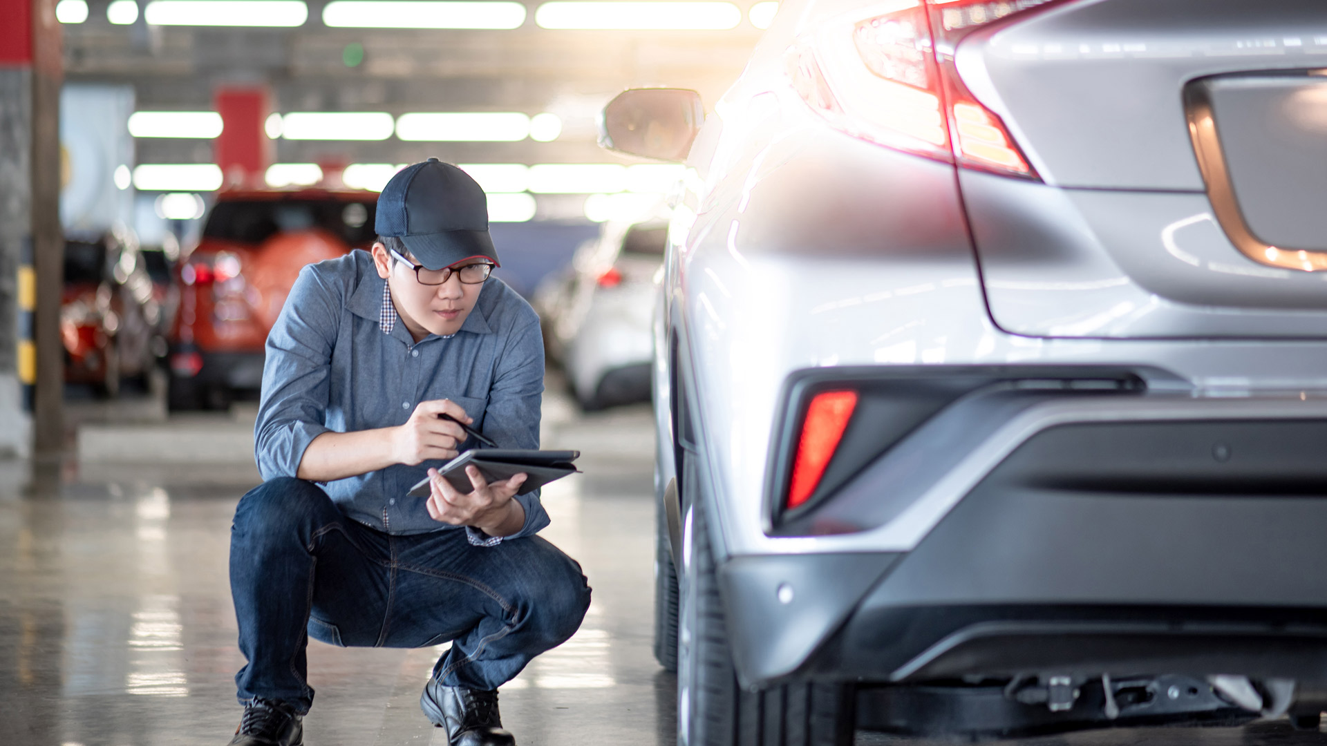 Mechanic checking car repairs on a tablet inside vehicle repair shop