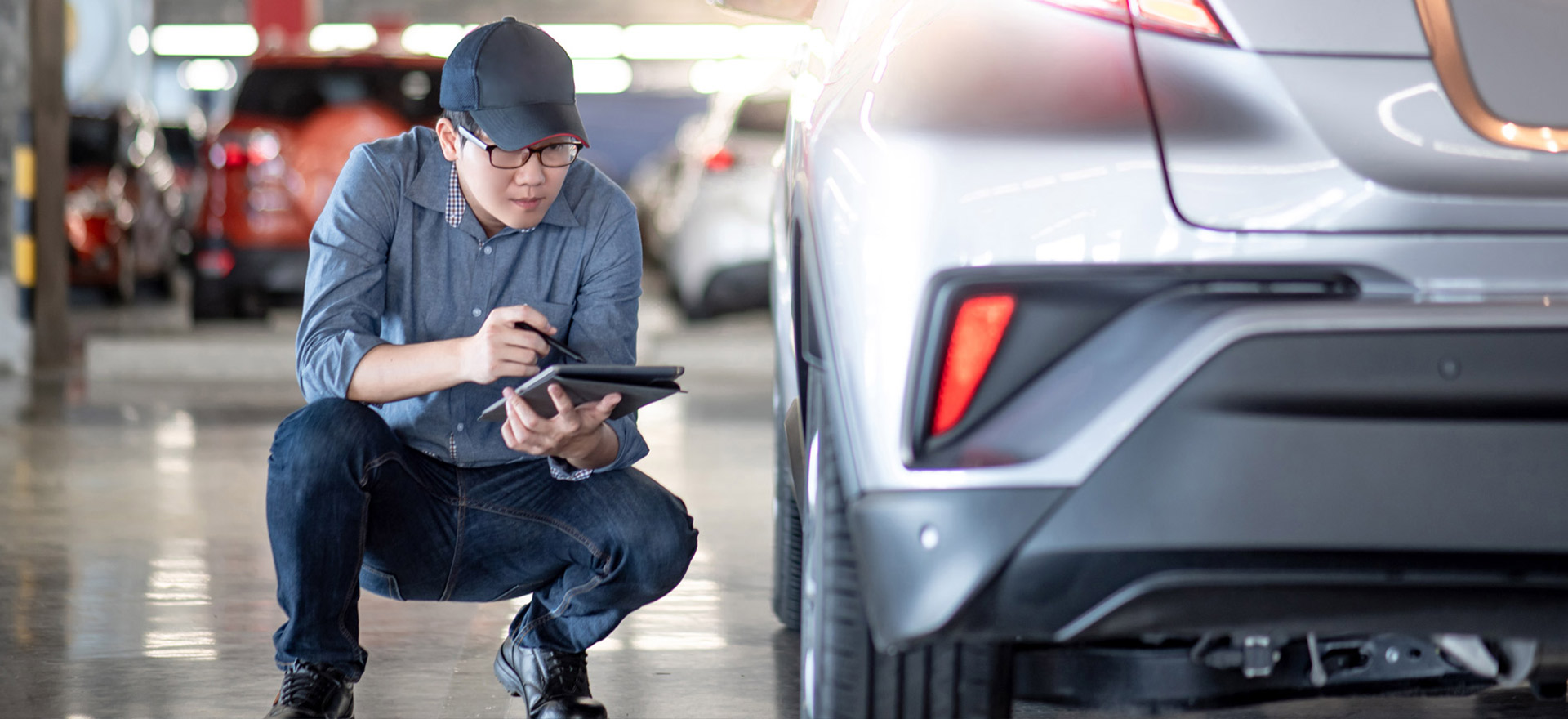 Mechanic on a tablet checking repair shop fixes on car